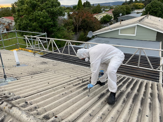 Man removing nails of Asbestos Roof