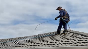 Person Roof Cleaning on a Concrete Roof
